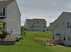 two white houses with red shutters on the front and one in the back yard