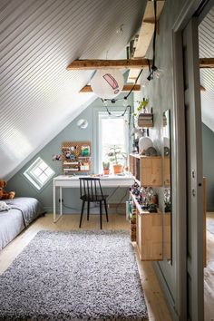 an attic bedroom with a desk and bed