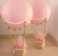 two pink and gold paper lanterns in baskets