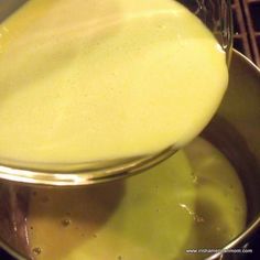 a pan filled with yellow liquid on top of a stove