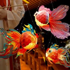 three colorful paper fish hanging from strings