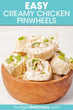 a wooden bowl filled with creamy chicken pinwheels