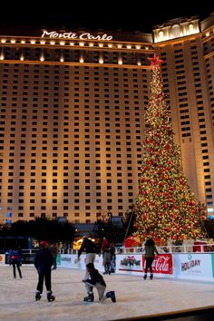 people skating around an ice rink with a christmas tree in front of the mirage hotel