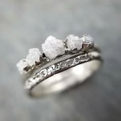 three pieces of white gold and diamond wedding ring set on top of each other,