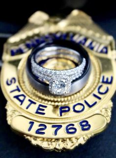 a police badge with two wedding rings on it