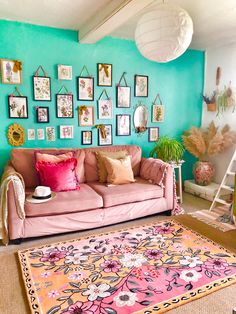 a living room with pink couches and pictures on the wall above it, along with rugs