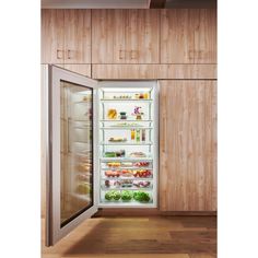 an open refrigerator with its doors wide open in a kitchen area that has wood paneling on the walls and wooden flooring