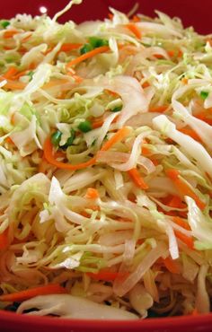 a red bowl filled with coleslaw and carrots