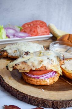 a sandwich with meat and cheese on a wooden board