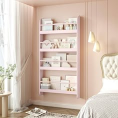 a bedroom with pink walls and shelves filled with boxes on the wall next to a bed