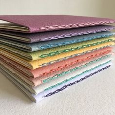 a stack of different colored papers sitting on top of a white tablecloth covered in paper chains