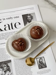 two chocolate truffles sitting on top of a magazine