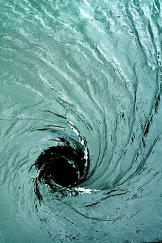 a black hole in the water that is very close to it's surface and looks like an ocean wave