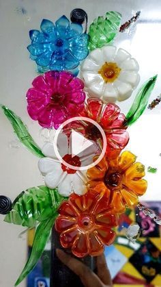 colorful flowers are being held up by someone's hand