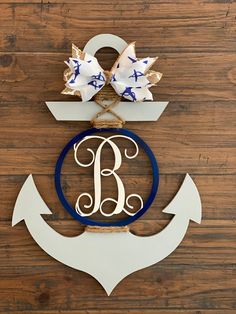 an anchor and bow hanger on the wall with a monogrammed letter b