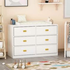 a baby's room with a dresser, crib and toys on the floor