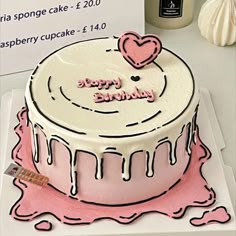 a birthday cake with pink icing and hearts on top is sitting on a table