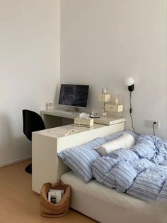 a bedroom with a bed, desk and computer on the table in front of it