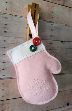 a pink oven mitt hanging on a wooden wall