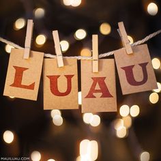 several small pieces of paper with the word luau on them hanging from a string