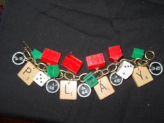 a close up of a bracelet with dice and letters on it, all in different colors