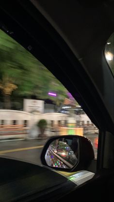 a car's rear view mirror is seen through the windshield as it drives down the street