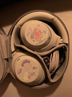 two white headphones sitting in a case