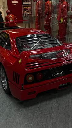 a red sports car parked in front of a glass display case