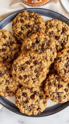 chocolate chip oatmeal cookies on a plate next to a jar of peanut butter