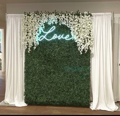 a white backdrop with flowers and the word love is on display in front of a doorway