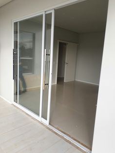 an empty room with sliding glass doors on the outside and a person standing in the doorway