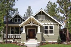 a gray house with white trim on the front porch and stairs leading up to it