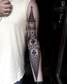 a man with a castle tattoo on his arm