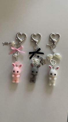 four keychains with different types of animals and hearts hanging from them on a table