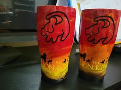 two red and yellow cups sitting on top of a black table next to each other