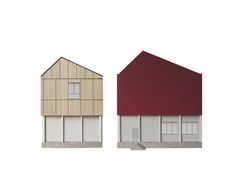 two houses with red roofs and white walls, one is made out of plywood