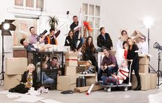 a group of people are posing for a photo in front of boxes and other items