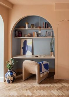 a living room with an arch in the wall and a chair next to it on top of a hard wood floor