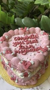 a heart shaped cake sitting on top of a table next to flowers and greenery