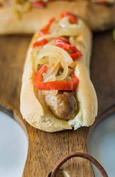 a hot dog on a bun with onions and peppers