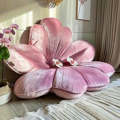 a large pink flower sitting on top of a wooden floor