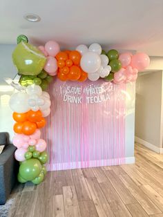 a room filled with balloons and other items on the floor next to a wall that says,