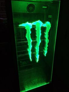 the monster energy drink is glowing green in the dark