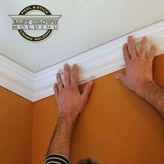 a man is working on the ceiling with his hands in front of him and an emblem above it