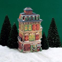 a christmas scene with a lit up building in the snow