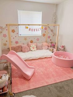 a child's bedroom decorated in pink and gold with a slide, bedding, rugs and toys