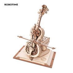 a wooden model of a violin on top of a book with an intricately carved design