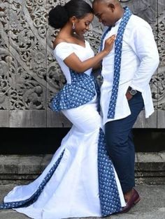 a man and woman dressed in blue and white posing for the camera with their arms around each other