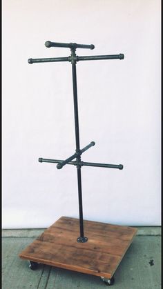 a wooden stand with four metal bars on it's top and two black poles in the middle