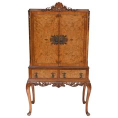 an old wooden cabinet with ornate carvings on the doors and drawers, sitting against a white background